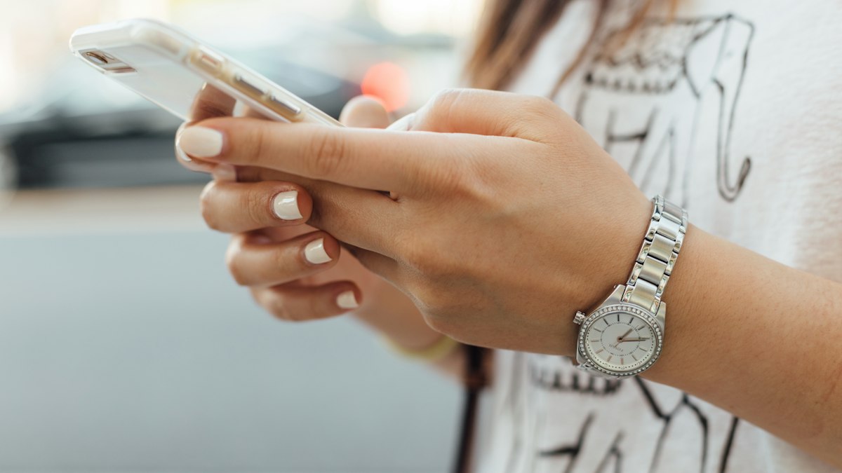 A woman using her smartphone, the screen turned away
